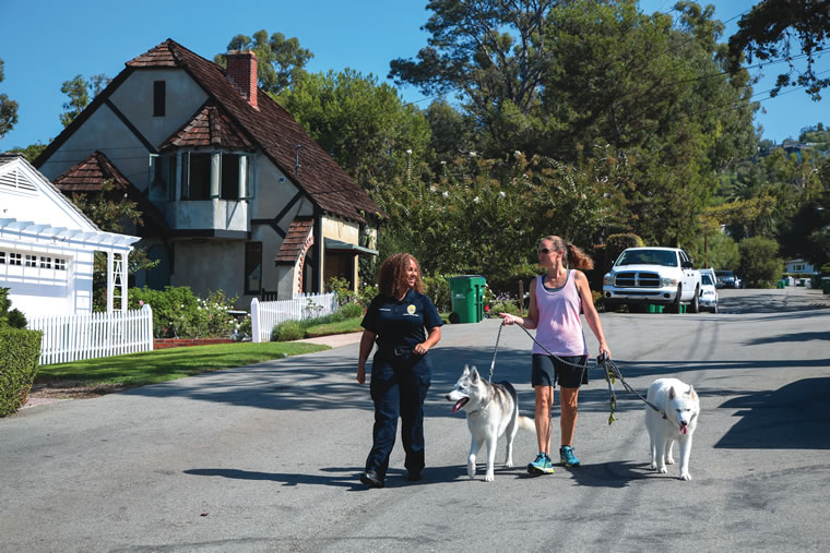 Natasha Hernandez (left) educates local dog walkers about keeping an eye out for suspicious activity.