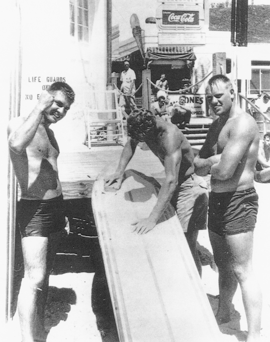 working on a surfboard near the diner owned by Dick Metz’s dad at Main Beach_credit Surfing Heritage and Culture Center/Dick Metz Collection/shacc.org
